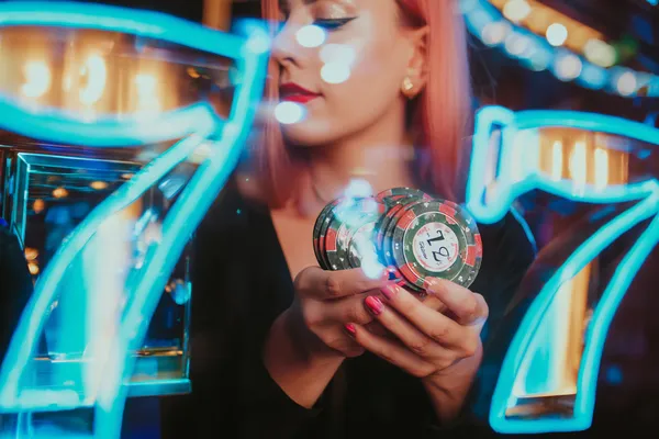 A young woman relaxing with her phone while dynamic casino elements float around her, illustrating the smooth mobile experience offered by the 8777BET app.